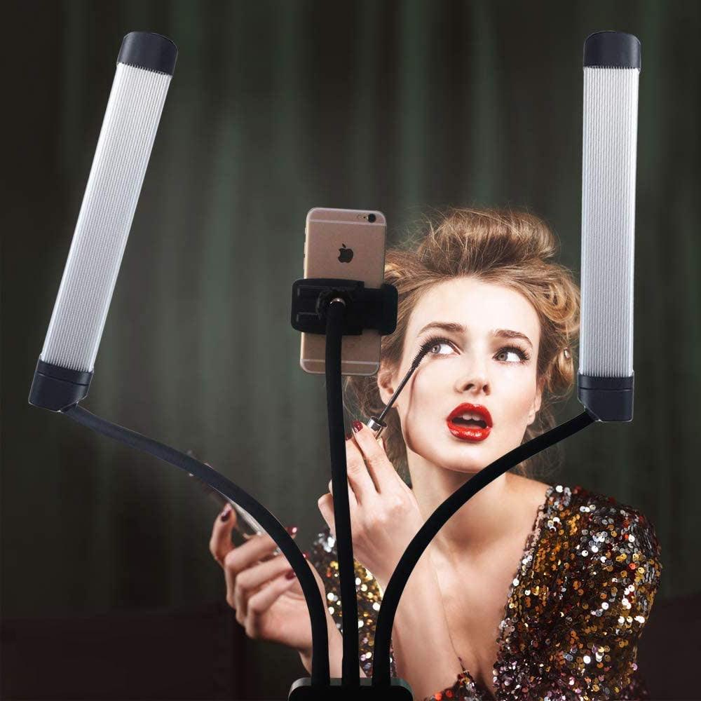 Woman applying mascara using phone and salon light